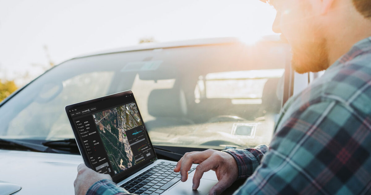 man using pigview pig tracking software on laptop in the field