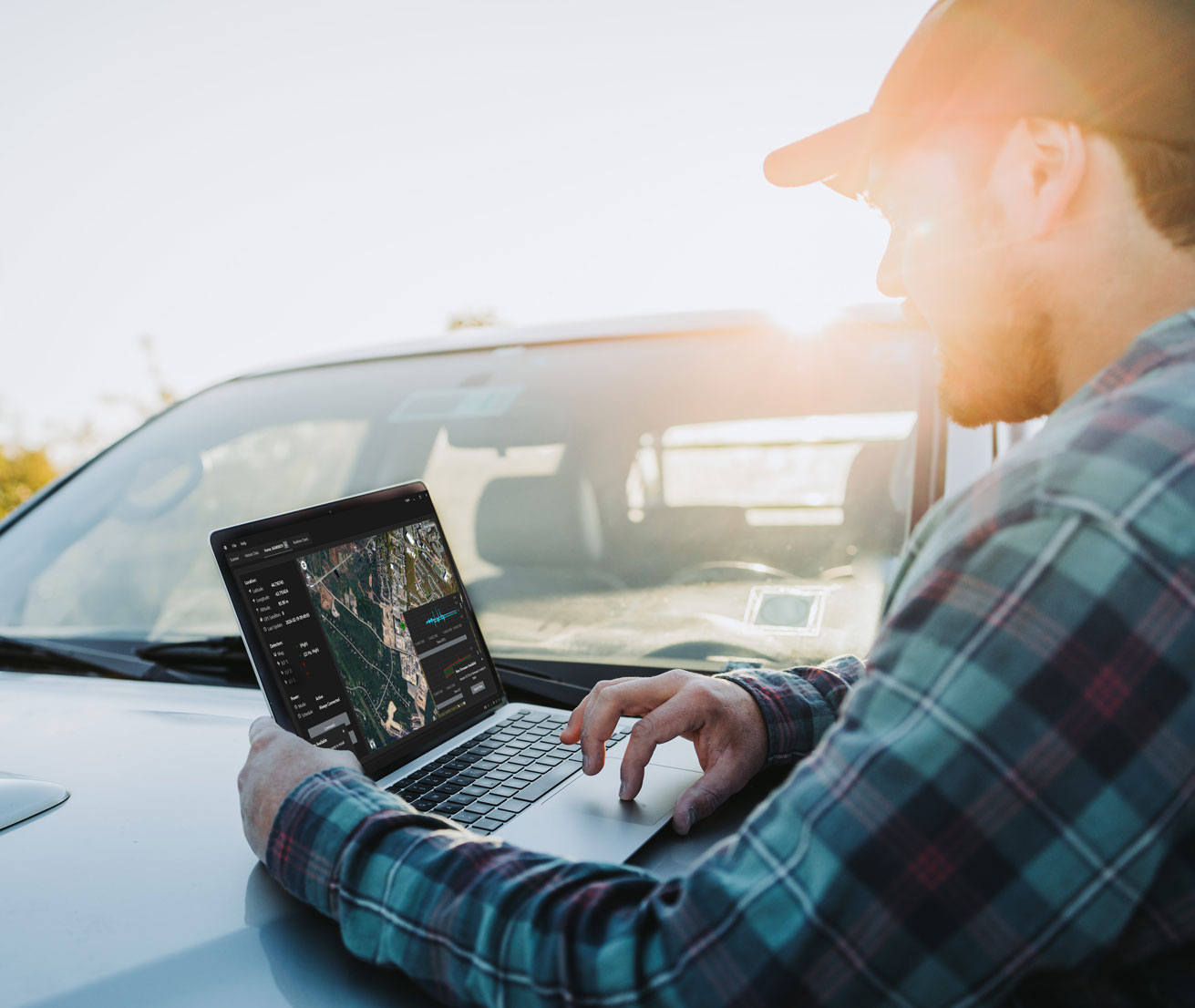 man using pigview pig tracking software on laptop in the field